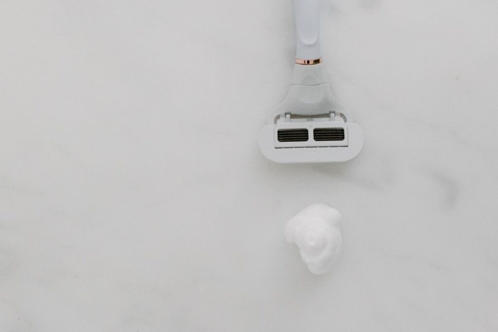 Razor and shaving cream flat lay, showing the tools for shaving the bikini line without bumps