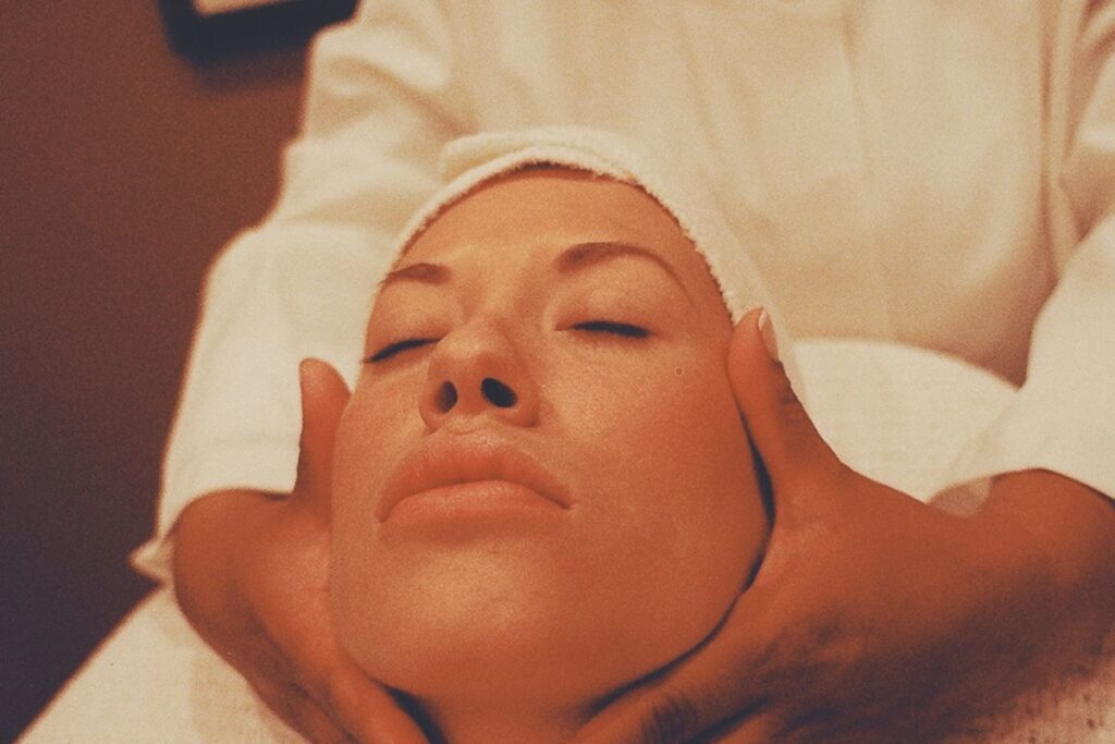 Facial massage for wrinkles: hands performing an upward massage technique on the cheeks and jawline