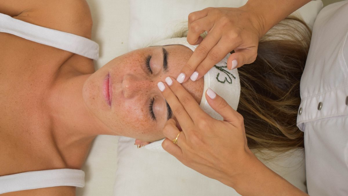 Woman receiving a relaxing facial massage with eyes closed, illustrating facial massage for wrinkles