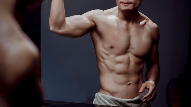 Athletic man grooming in front of a mirror, illustrating IPL hair removal for men