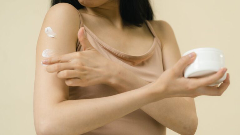 Woman applying moisturiser to her arm to manage keratosis pilaris on the arms